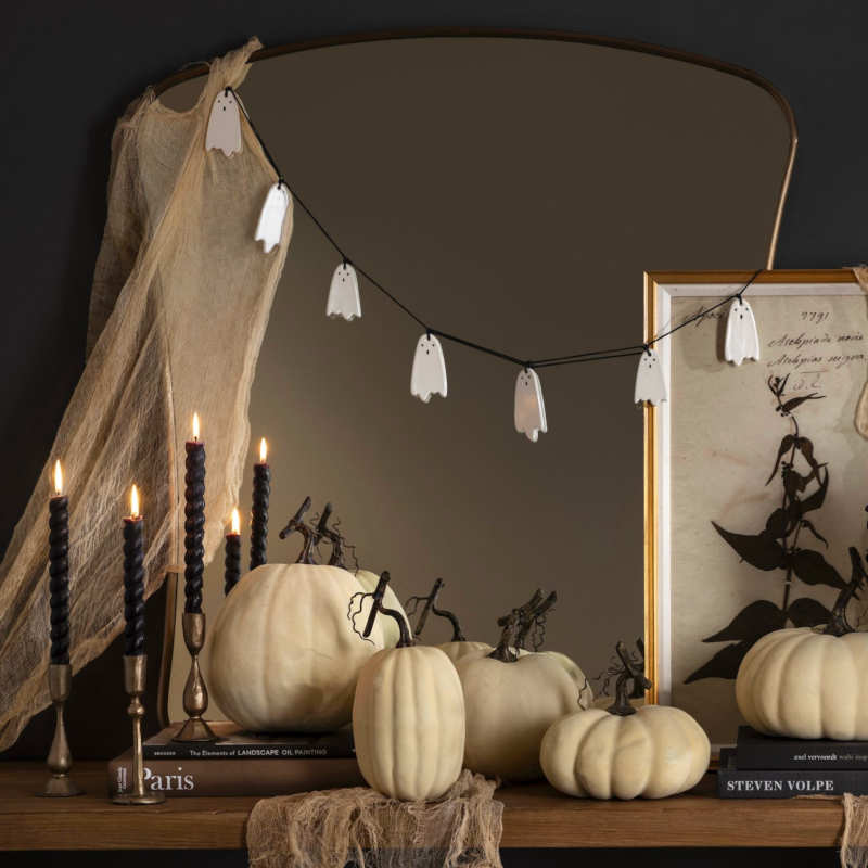 décoration console bois pour halloween avec guirlande fantômes, bougies noires, citrouilles ou courges blanches