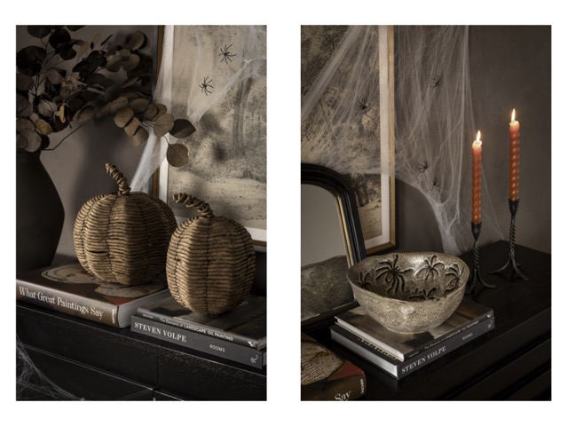 scènographie halloween avec citrouilles en rotin, bougies marrons, chandelier noir en métal, livres décoratifs et bol brut