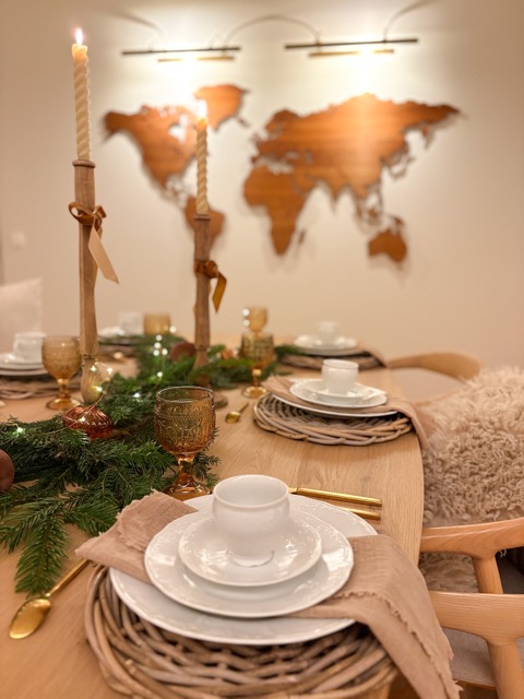 scénographie table de noel avec gaze de coton, osier, bois, verre ambré, sapin et bougies