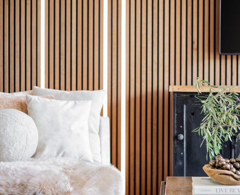 mur bois massif avec rubans led intégrées Ledux, peau de bête, coussin boule pou run Intérieur minimaliste et chaleureux