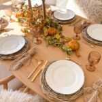 Décor mise en scène table automnale avec feuilles mortes, bougies et osier