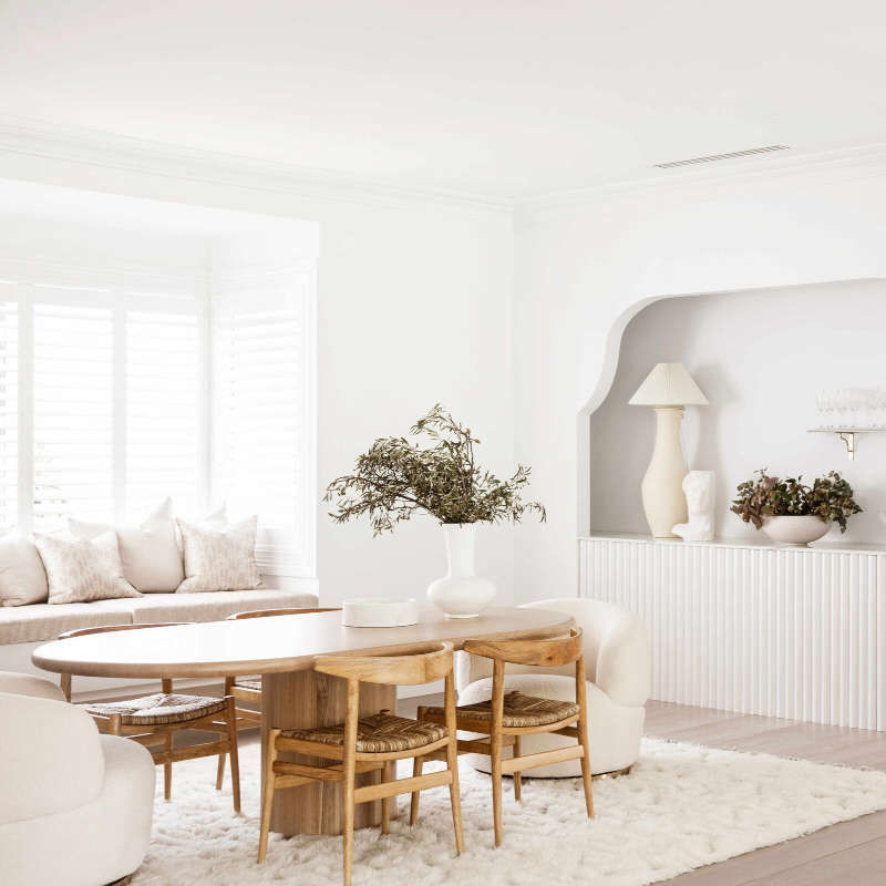 salle à manger blanche avec table et chaises en bois niche moulure arrondi